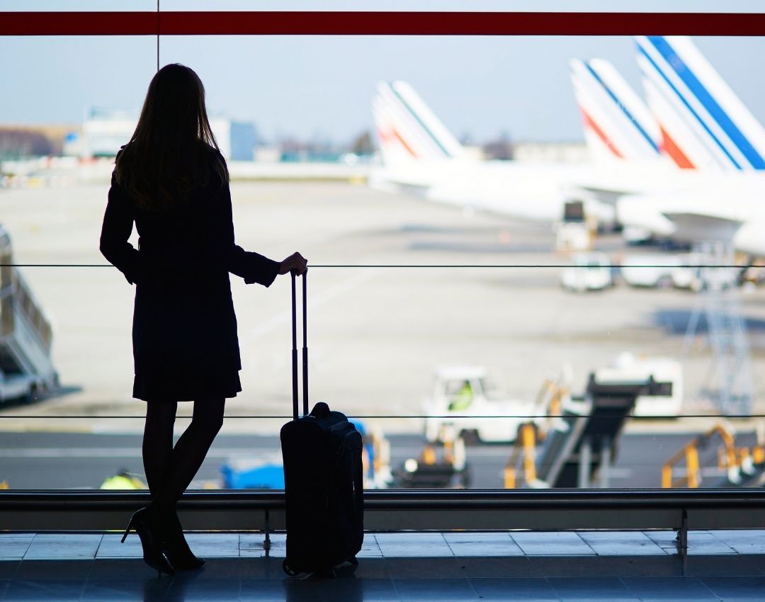 Business professional with luggage at airport, representing solo travel safety and security